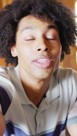 vertical video of african american man having video call in log cabin