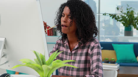 Thoughtful-female-executive-working-on-computer-at-desk-4k