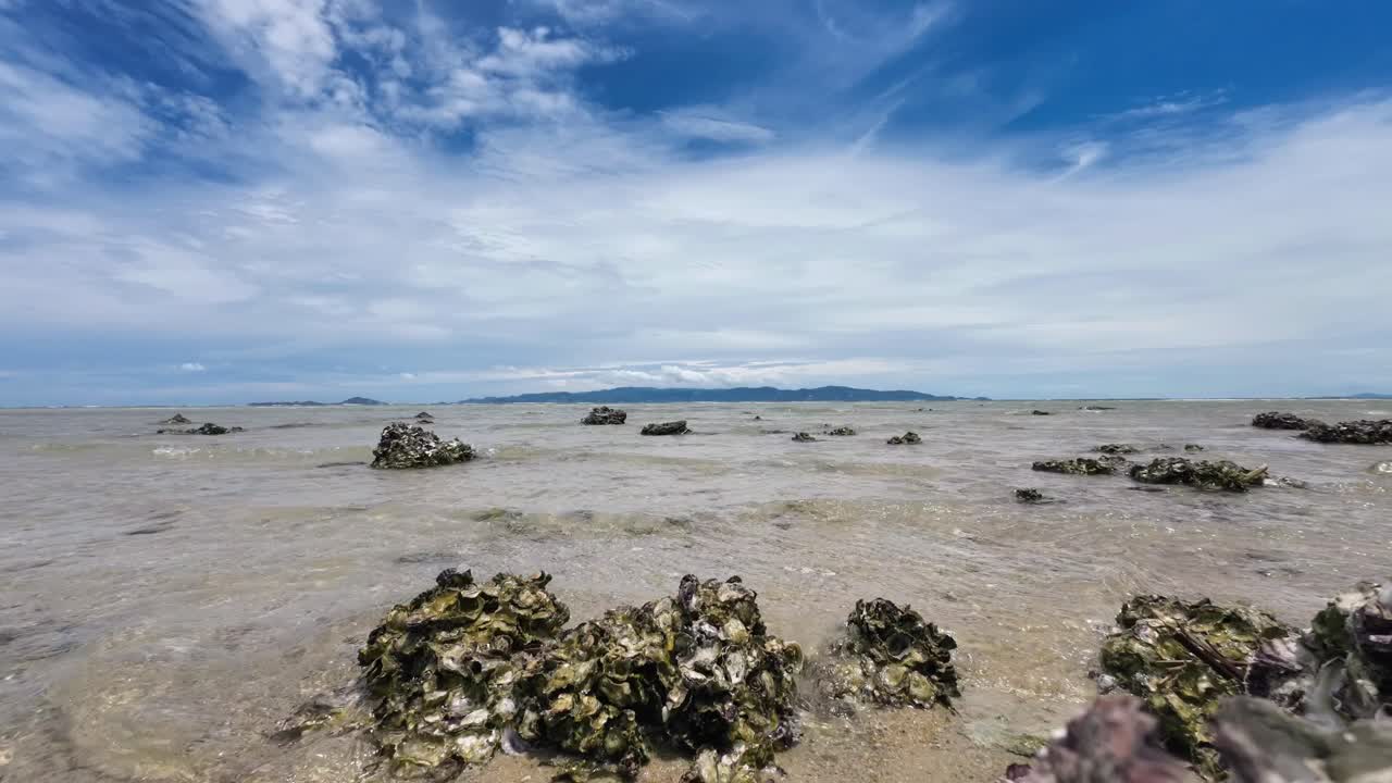 Timelapse video showing clouds drifting over Koh Samui as seen from Koh Phangan beach, with calm sea and tropical scenery