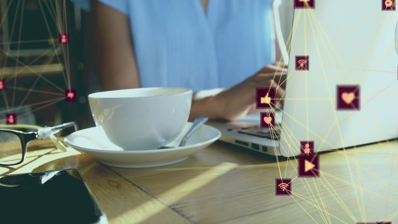 Floating tech icons appearing on laptop connecting while woman typing showing connectivity