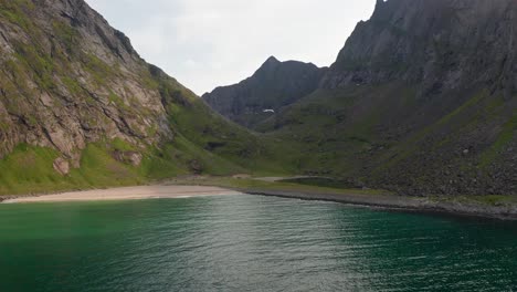 aerial shot of remote lofoten sandvika beach in noway surrounded by steep cliffs