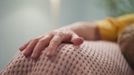 Senior-woman-wrinkled-hand-sitting-with-little-boy-in-room