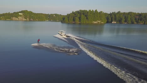 Wake-Boarder-Vuela-Como-Un-Acróbata-Sobre-Un-Bote-A-Motor-Wake-Wave-En-Un-Lago-Tranquilo