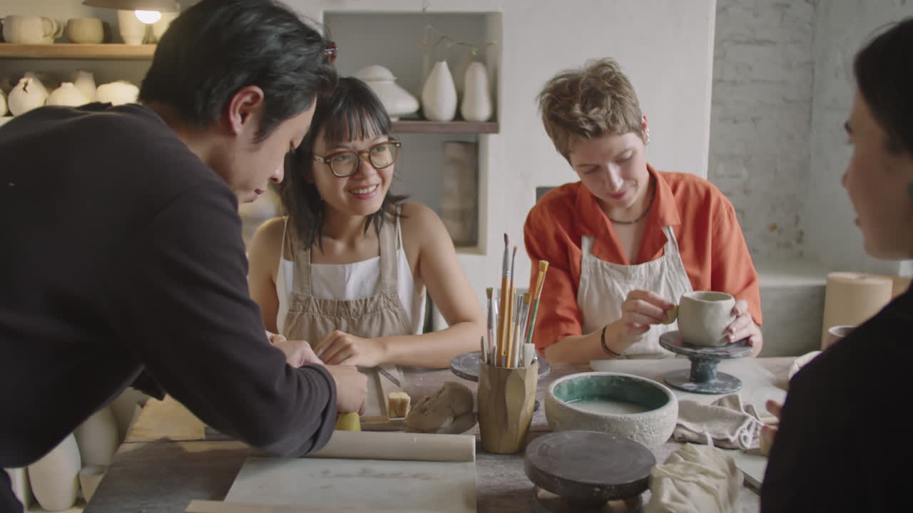 Pottery Teacher and Female Students Modeling Clay at Ceramics Lesson