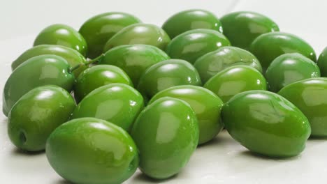 aceitunas verdes redondas en vinagre de grecia como fondo, vista de arriba. imágenes de alta calidad en 4k