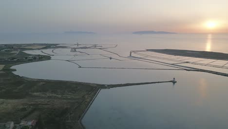 trapani salt pond aerial view at sunset with egadi islands at distance in mediterranean sea