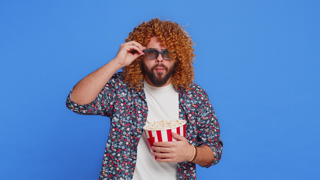 Excited man in 3d glasses eating popcorn watching interesting tv serial sport game cinema film