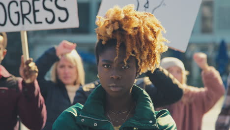 retrato de una manifestante femenina entre los manifestantes con pancartas en la manifestación black lives matter