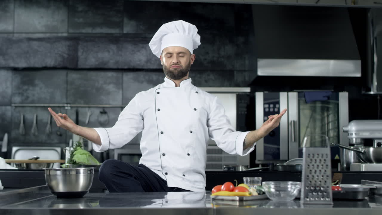 un chef posando en una cocina profesional, un chef burlándose de la postura de meditación.