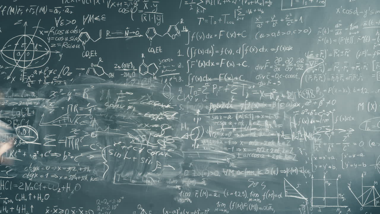 Student working on a heavily-written chalkboard