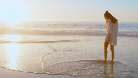 woman standing in the beach at dusk 4k