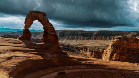 scenic and cinematic dark thunderstorm clouds time-lapse at the famous delicate arch rock among the arches national park hiking landmarks in utah, arizona, america usa