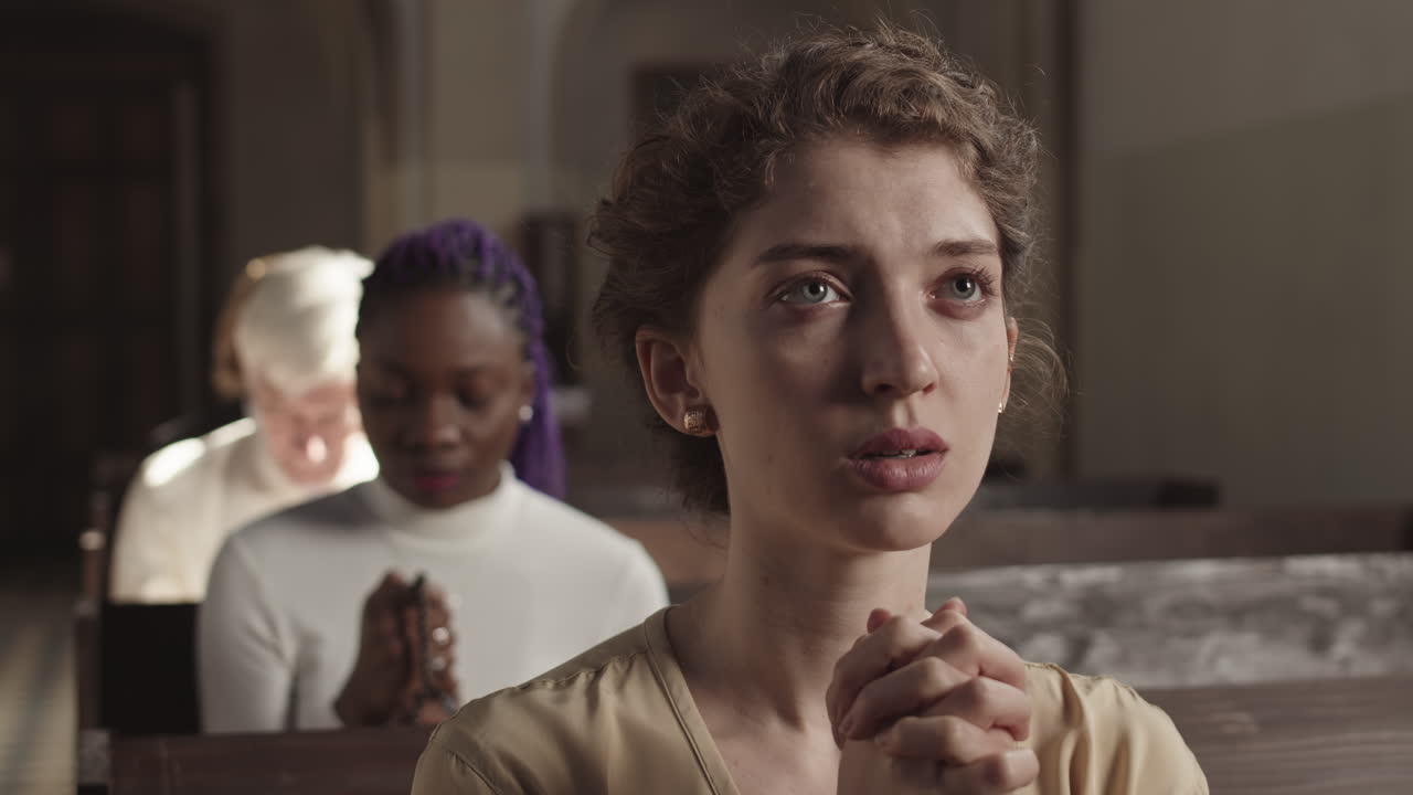 Young Female Parishioner Praying in Catholic Church