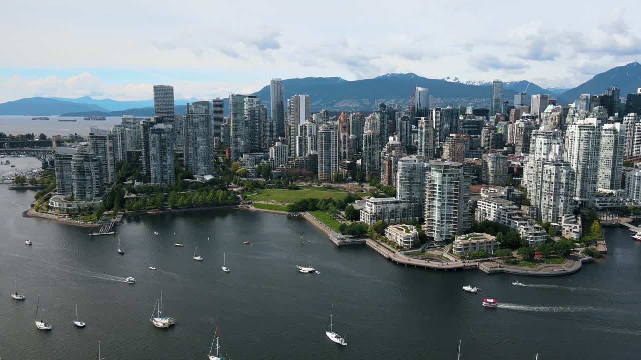 vista aérea que muestra muchos barcos en el río falls creek y la gigantesca torre de rascacielos de la ciudad de vancouver en el fondo - silueta de la cordillera en el fondo - vuelo de avión no tripulado en ascenso