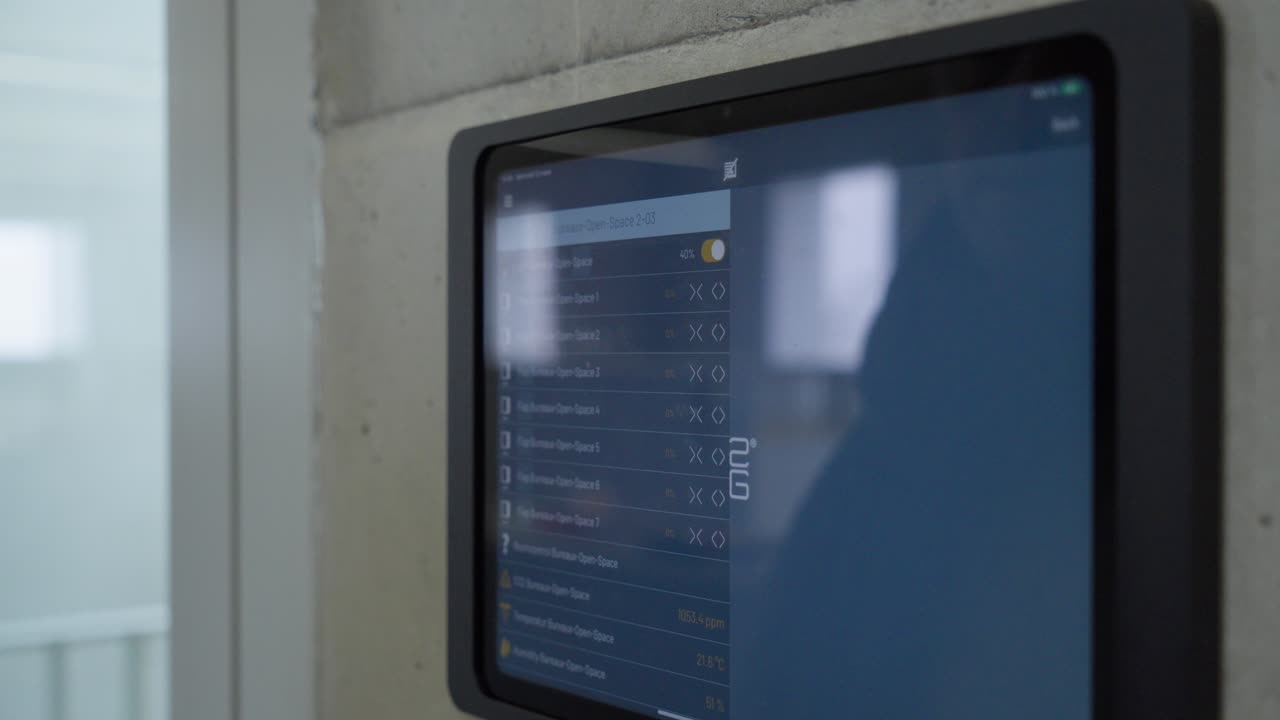 Man operates wall mounted touchscreen control panel in modern interior