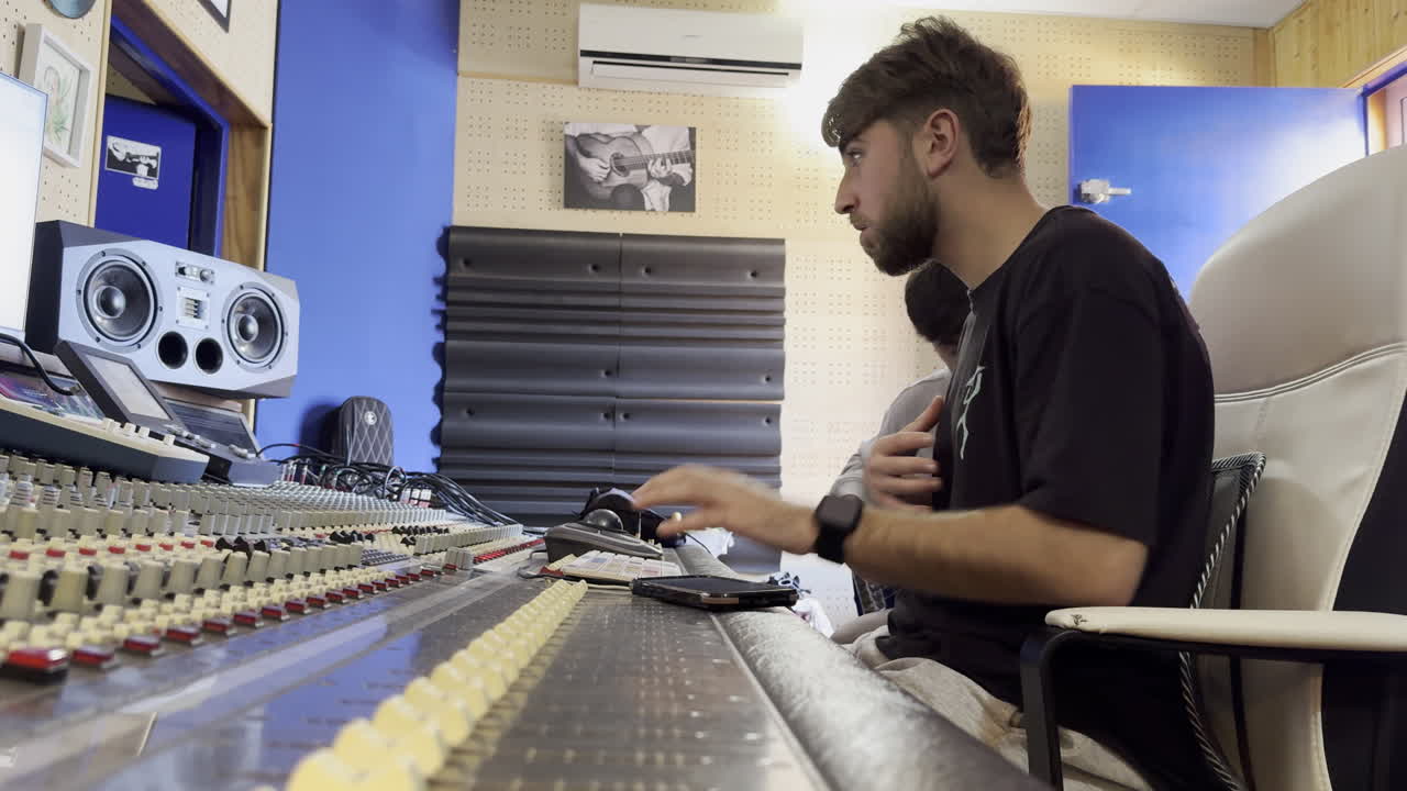 person working at recording studio workstation with mixing console