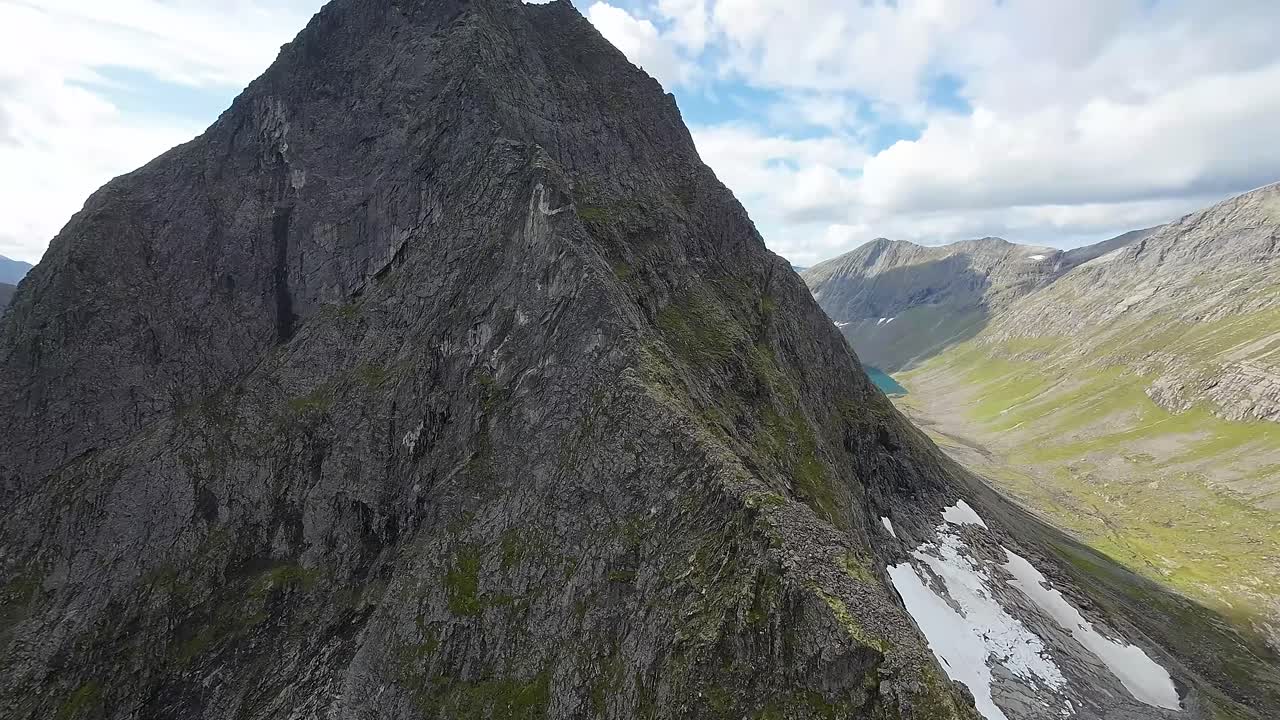 FPV drone defies gravity, ascends a mountain's rugged ridge, revealing an awe-inspiring world from an exhilarating, bird's-eye view