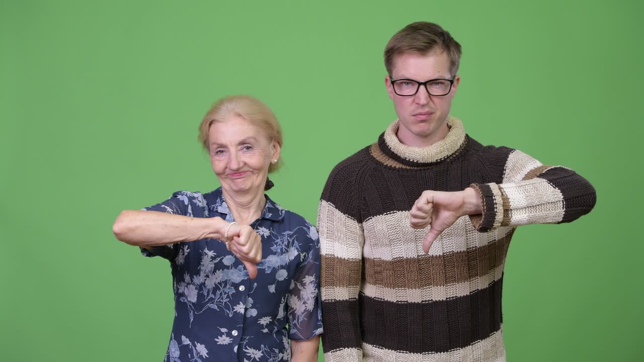 Angry grandmother and grandson giving thumbs down together