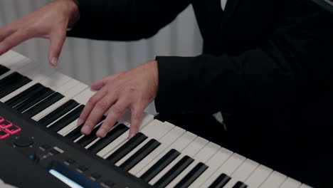 Close-up-of-a-musician's-hands-playing-a-digital-piano-keyboard-in-a-formal-setting