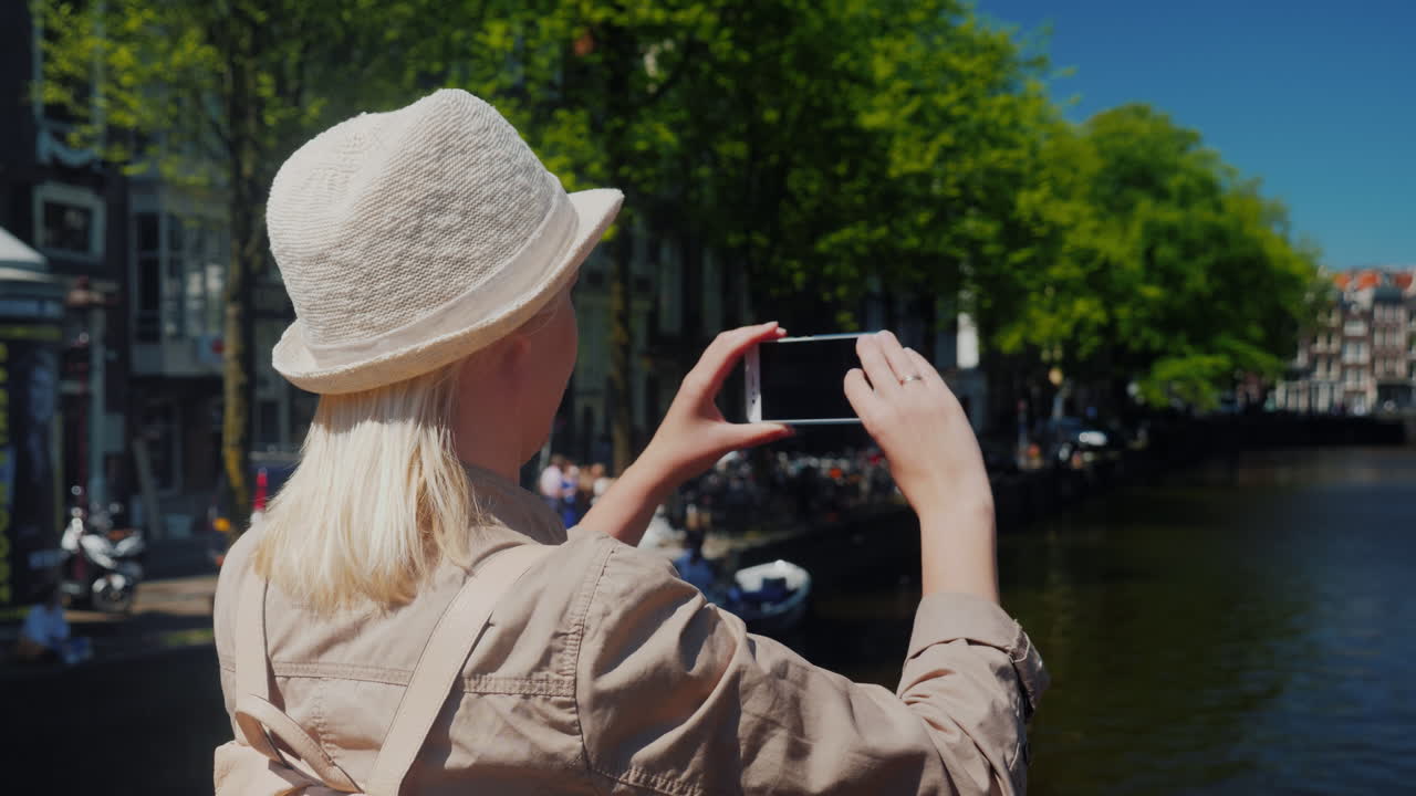 mujer toma foto canal en amsterdam