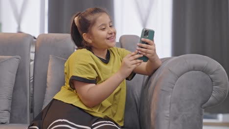 Indian-kid-girl-talking-to-someone-on-video-call-using-mobile-phone