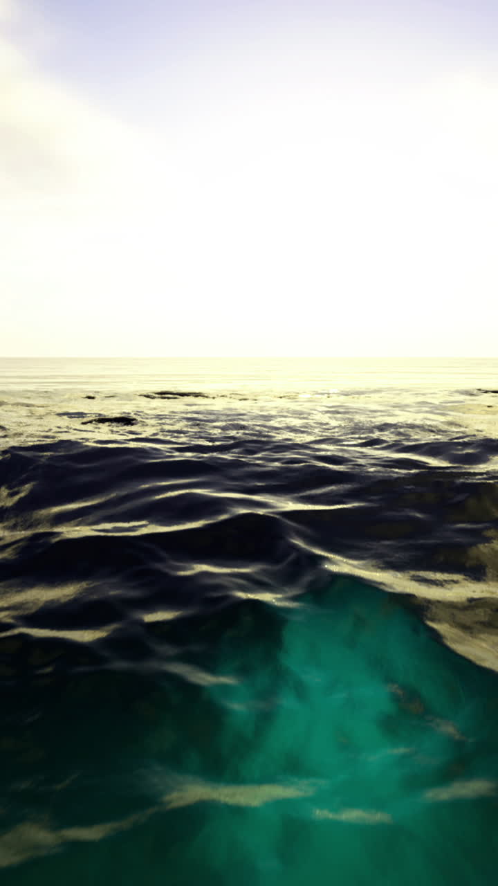 Ocean waves under a sunset sky create a serene landscape