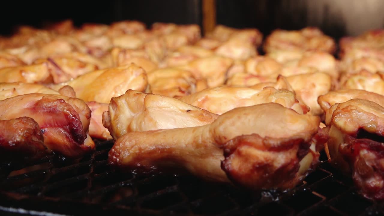 A large batch of golden-brown smoked chicken wings arranged on a grill rack. The wings appear juicy and well-cooked, ideal for barbecue or party servings.