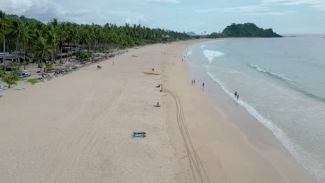 Lufttransportwagen-über-Touristen-Und-Reisenden,-Die-Nacpan-Beach,-El-Nido,-Palawan-Genießen