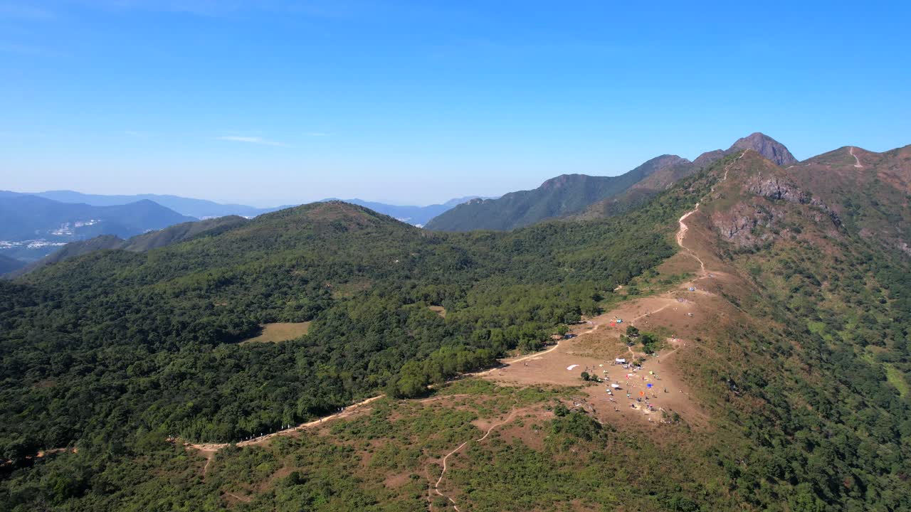 Splendida piana arida e brulla per il parapendio a Ngong Ping con una strada sterrata tortuosa che conduce alla cima a Ma On Shan, Hong Kong, in una limpida e soleggiata giornata estiva.