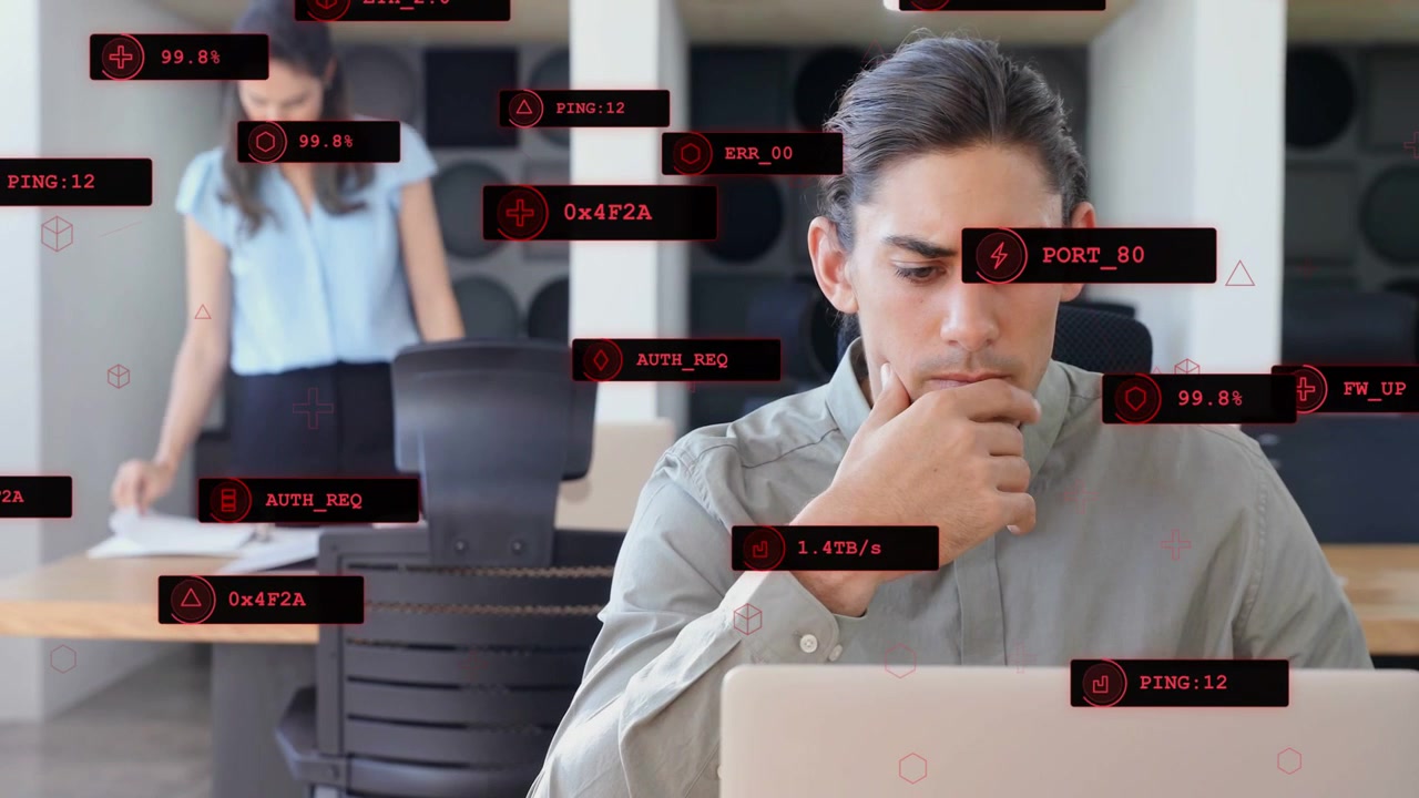 Homem no laptop ativando sobreposições HUD enquanto mulher organiza papéis, monitorando o status da rede.