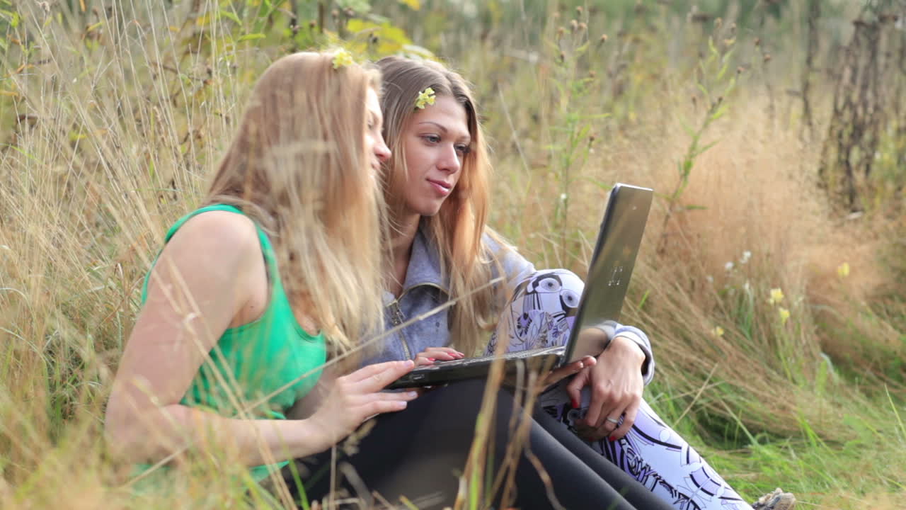 Female friends with laptop outdoor