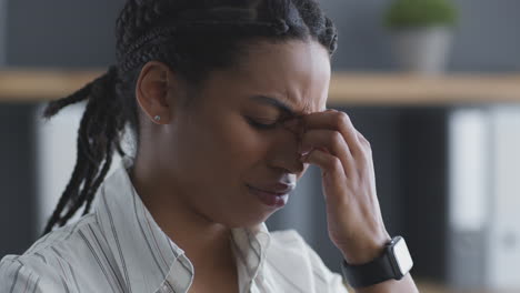 woman experiencing headache in office