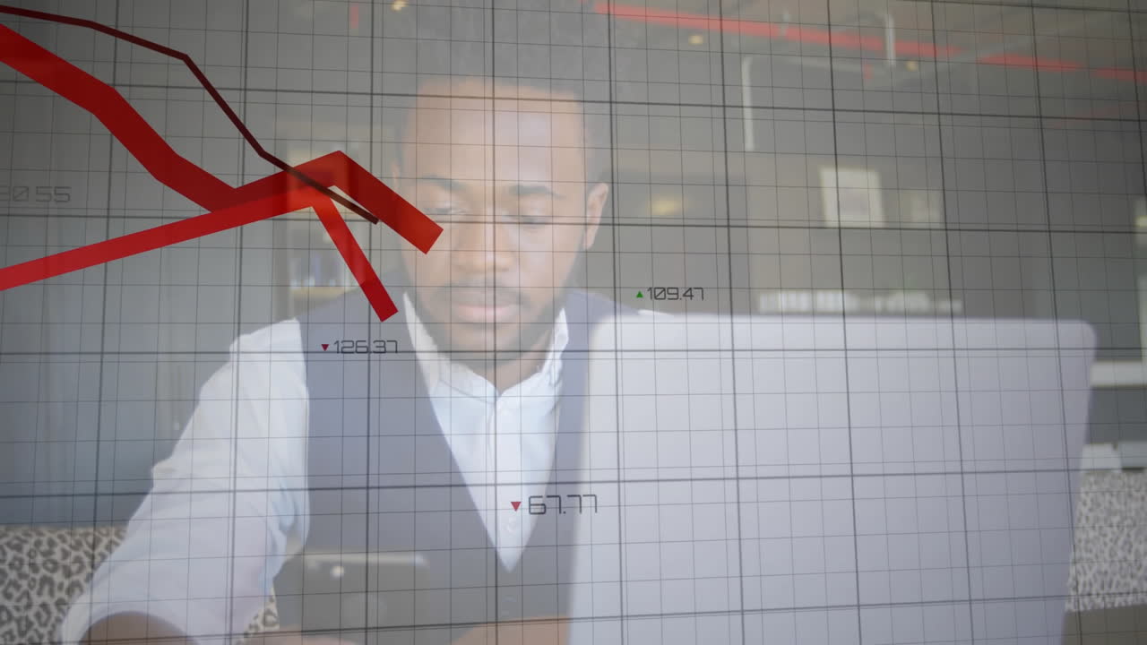 man using laptop at desk in business office, showing red line graph and grid overlay
