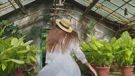 woman enjoying a sunny day in a greenhouse