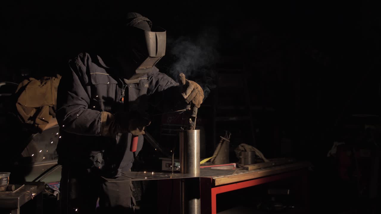 Saldatore che fabbrica tubazioni in acciaio inossidabile controllando l'elettrodo