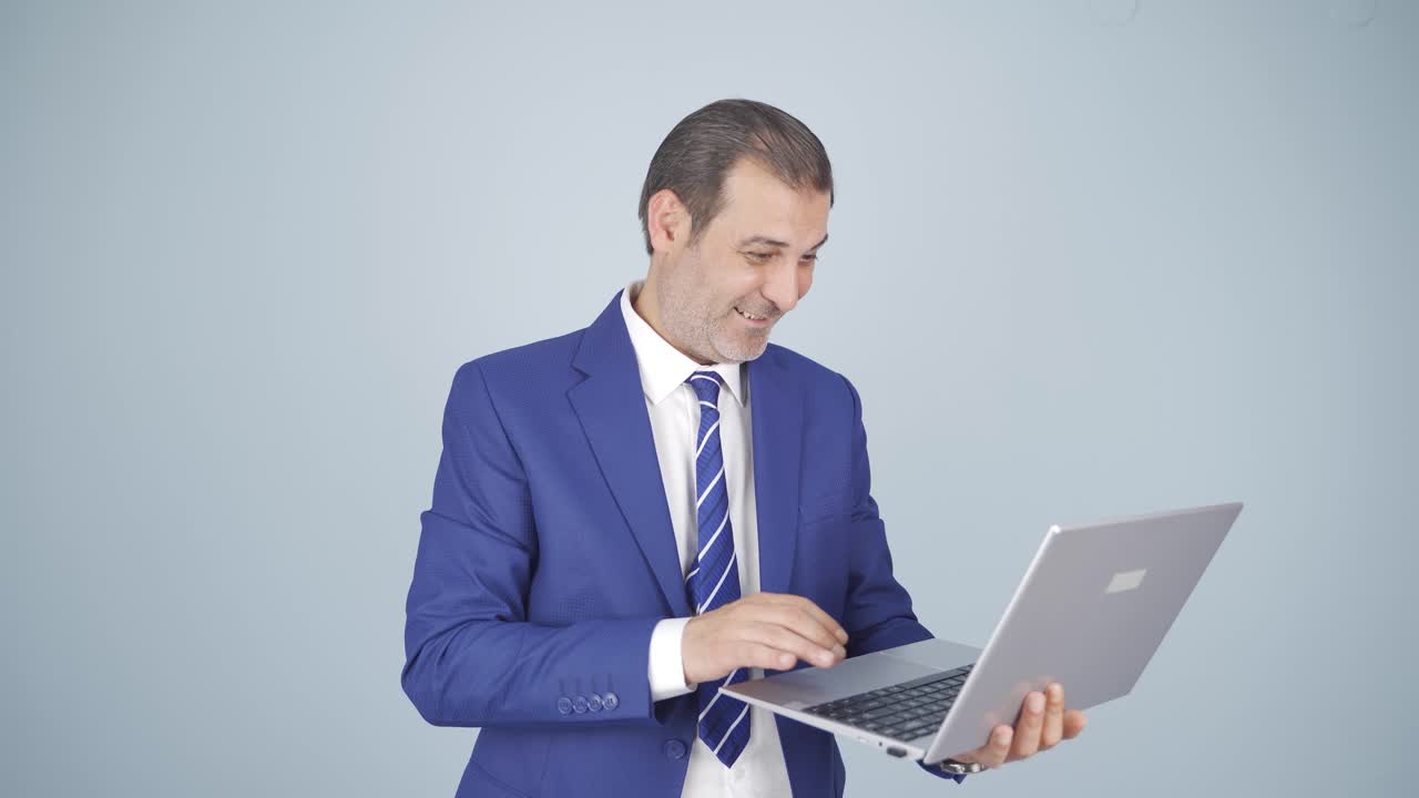 hombre de negocios mirando la computadora portátil con emoción.