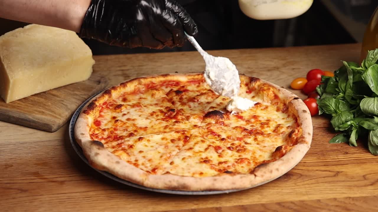 Chef che aggiunge ricotta fresca a una deliziosa pizza Margherita