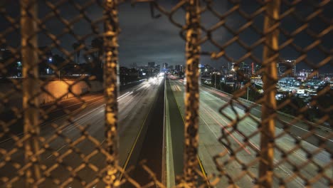 timelapse mirando a través del agujero de la valla en el tráfico de la ciudad de san diego