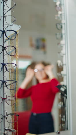 woman trying eyeglasses. beautiful woman choosing glasses in optician store