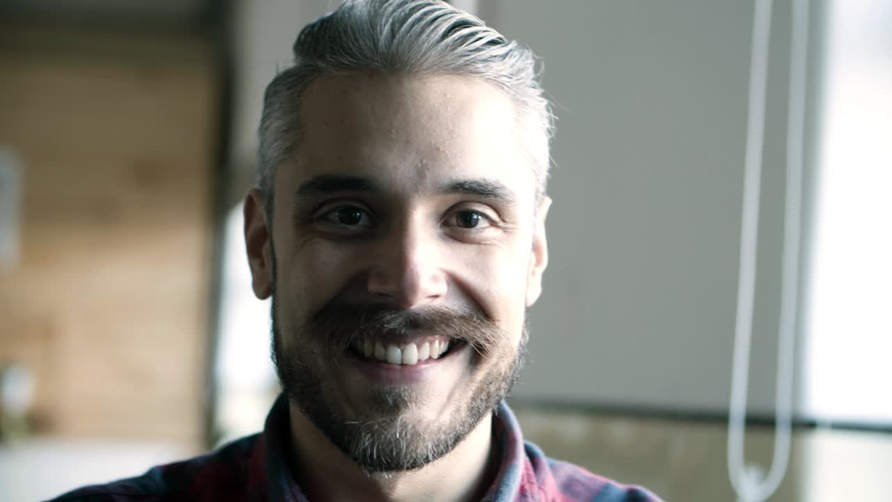 un joven alegre y sonriente con el cabello gris