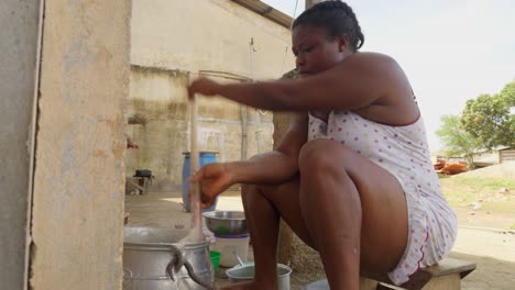 Woman-prepares-traditional-cornmeal-mush,-a-traditional-Ghanaian-dish-called-Banku