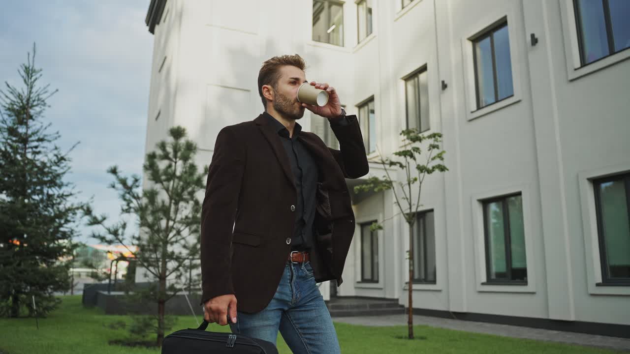 Uomo d'affari che cammina e beve caffè all'aperto
