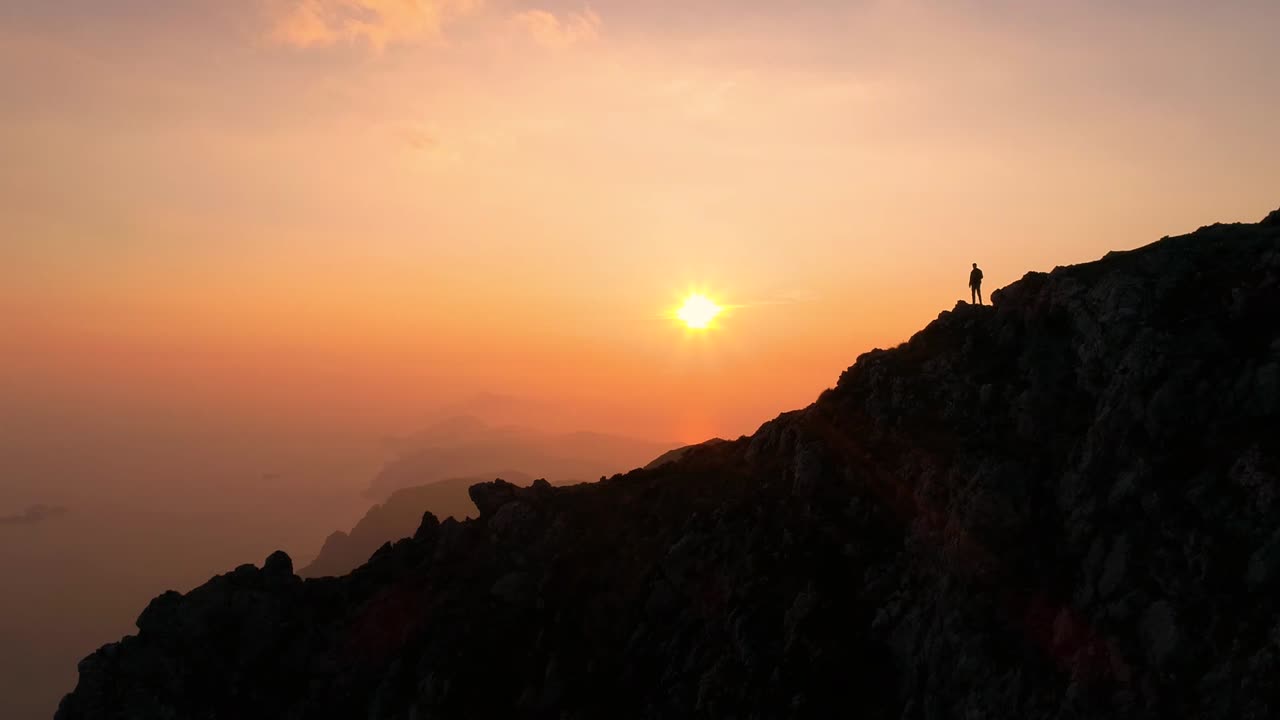 Un ragazzo si gode il panorama dalla cima delle montagne.