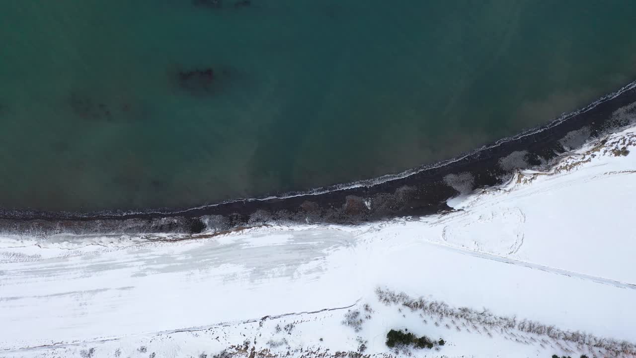 бирюзово-голубой океан и побережье, покрытое белым снегом - живописный вид сверху в исландии - беспилотник сверху вниз