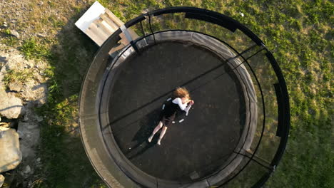 bored child lying in trampoline. aerial birdseye rising