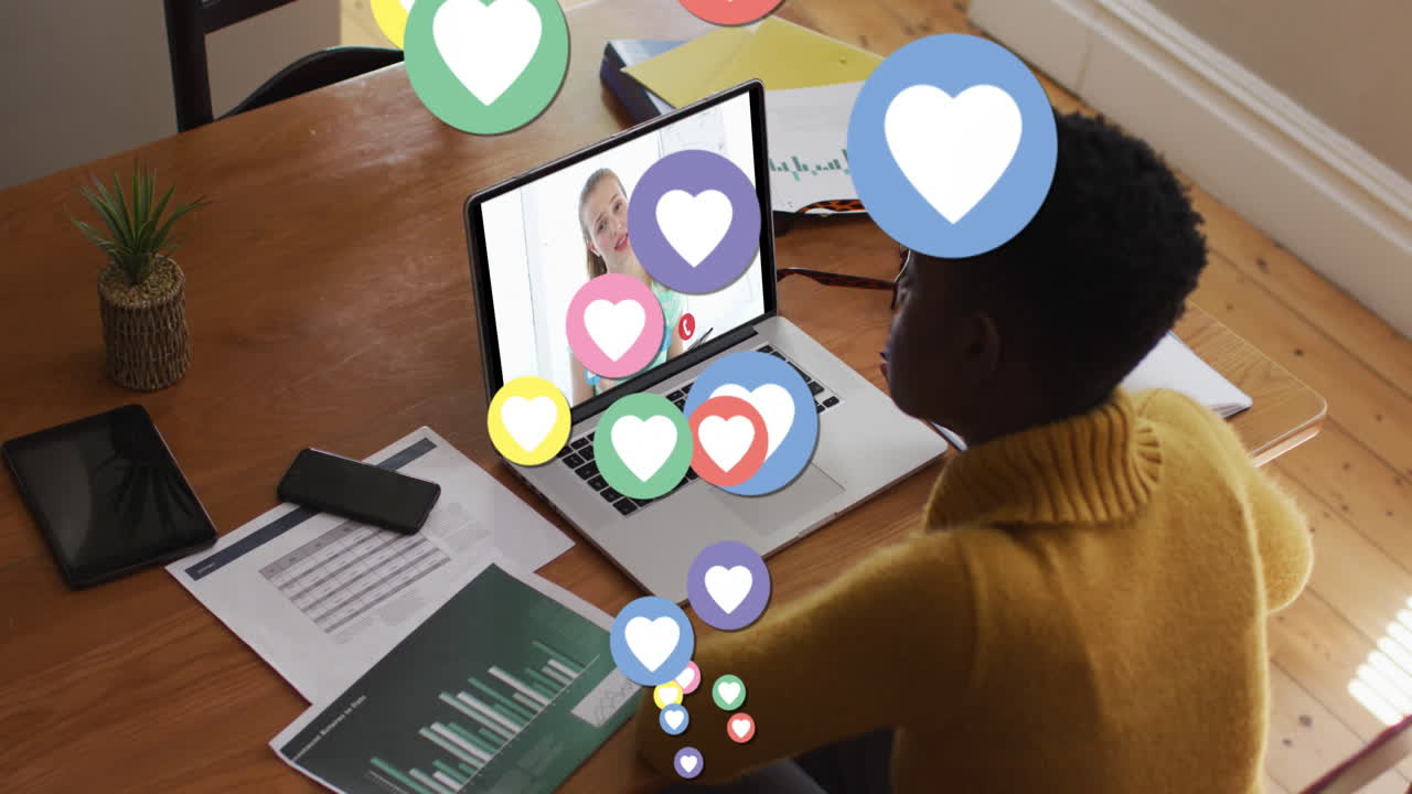 Animation of digital social media heart icons over woman using laptop on video call