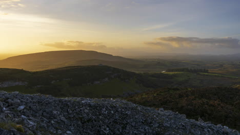 timelapse of rural nature landscape with hills in distance during evening with sun behind the clouds viewed from carrowkeel prehistoric passage tomb in county sligo in ireland