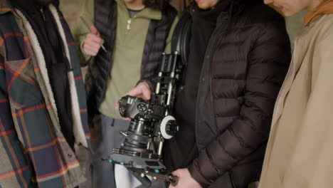 close up view of a production team and cameraman reviewing a scene in a camera in a ruined building