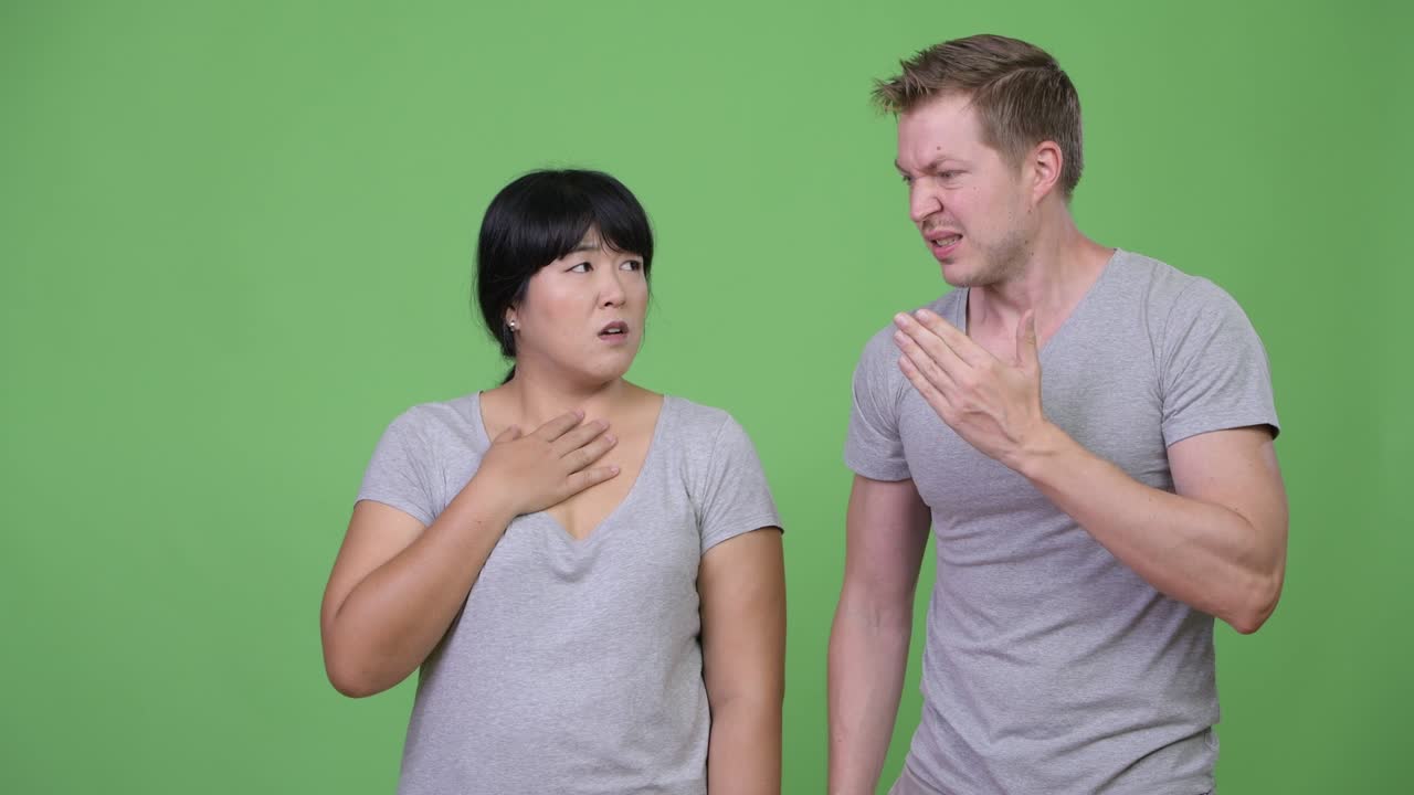 Young multi-ethnic couple looking shocked together