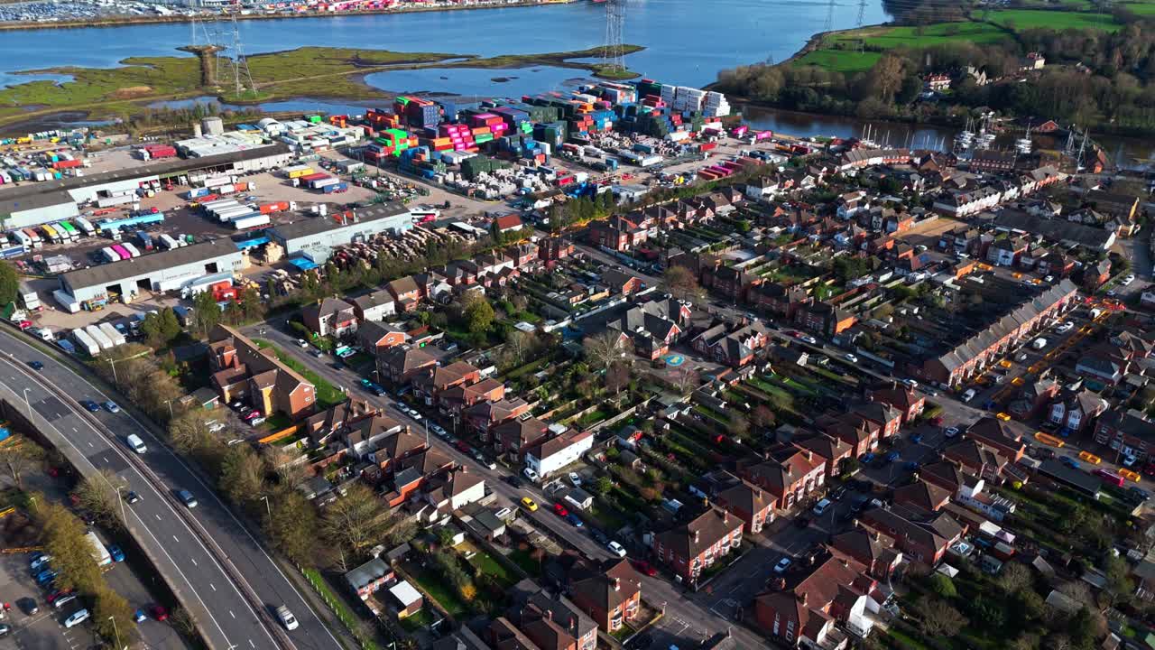 Panorerande flygfoto över förorten Totton väster om floden i Southampton, England, med bilar som kör på de livliga vägarna och solljus som reflekteras på det blå flodvattnet med båtar på under vintern.